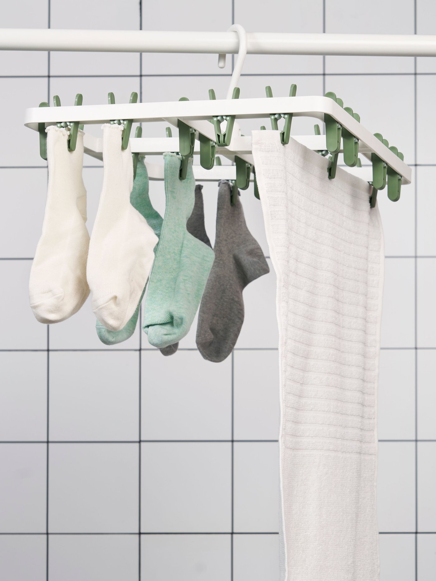 IKEA SLIBB green hang dryer with 24 clothes pegs in a bathroom or laundry room.