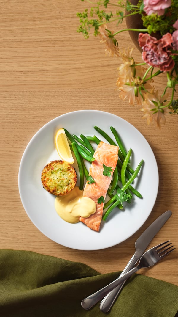 Laksefilet med grønnsaksmedaljong, bønnemiks og hollandaisesaus samt Daimkake og dispenserdrikke.