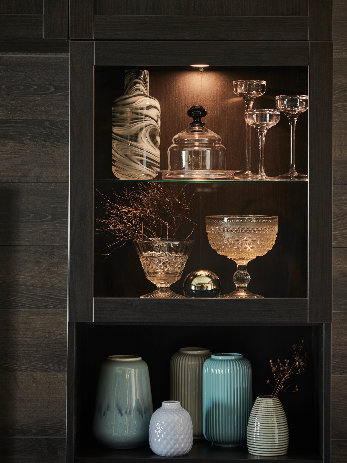 Black - Brown storage unit above a TV bench, storing vases and glassware
