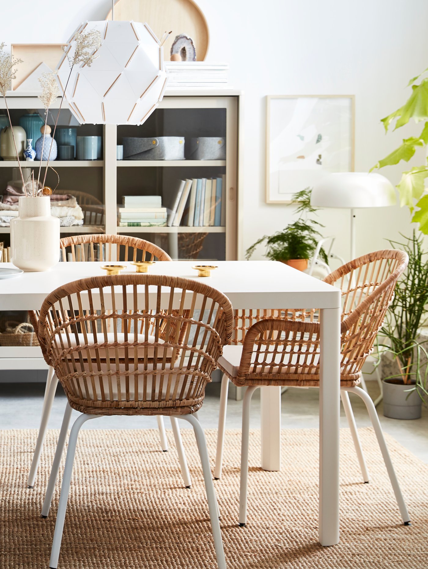 A dining table with rattan NILSOLVE dining chairs with a round SJÖPENNA pendant lamp in the dining room.