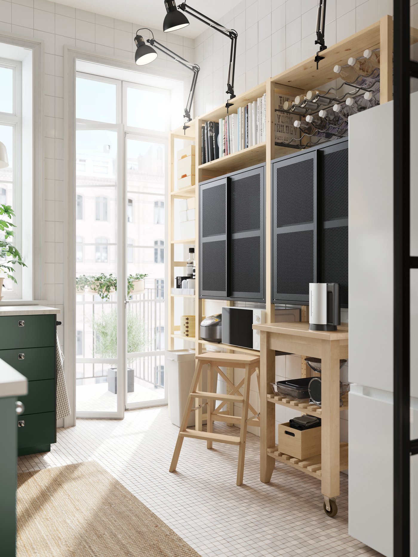 Una cucina molto luminosa con ante METOD verde intenso. Di fronte, una scaffalatura a giorno IVAR in pino con due mobili a rete nera con ante e portabottiglie.