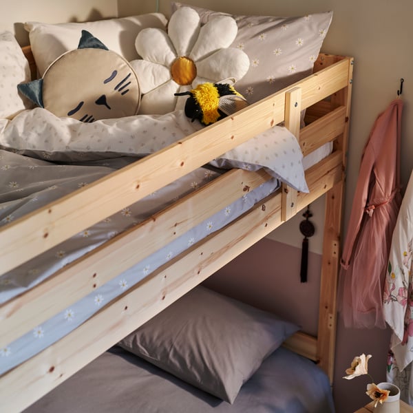 Grey and white NATTSLÄNDA bedding on the top bed of a MYDAL pine bunk bed, with a flower cushion and a soft toy on top.
