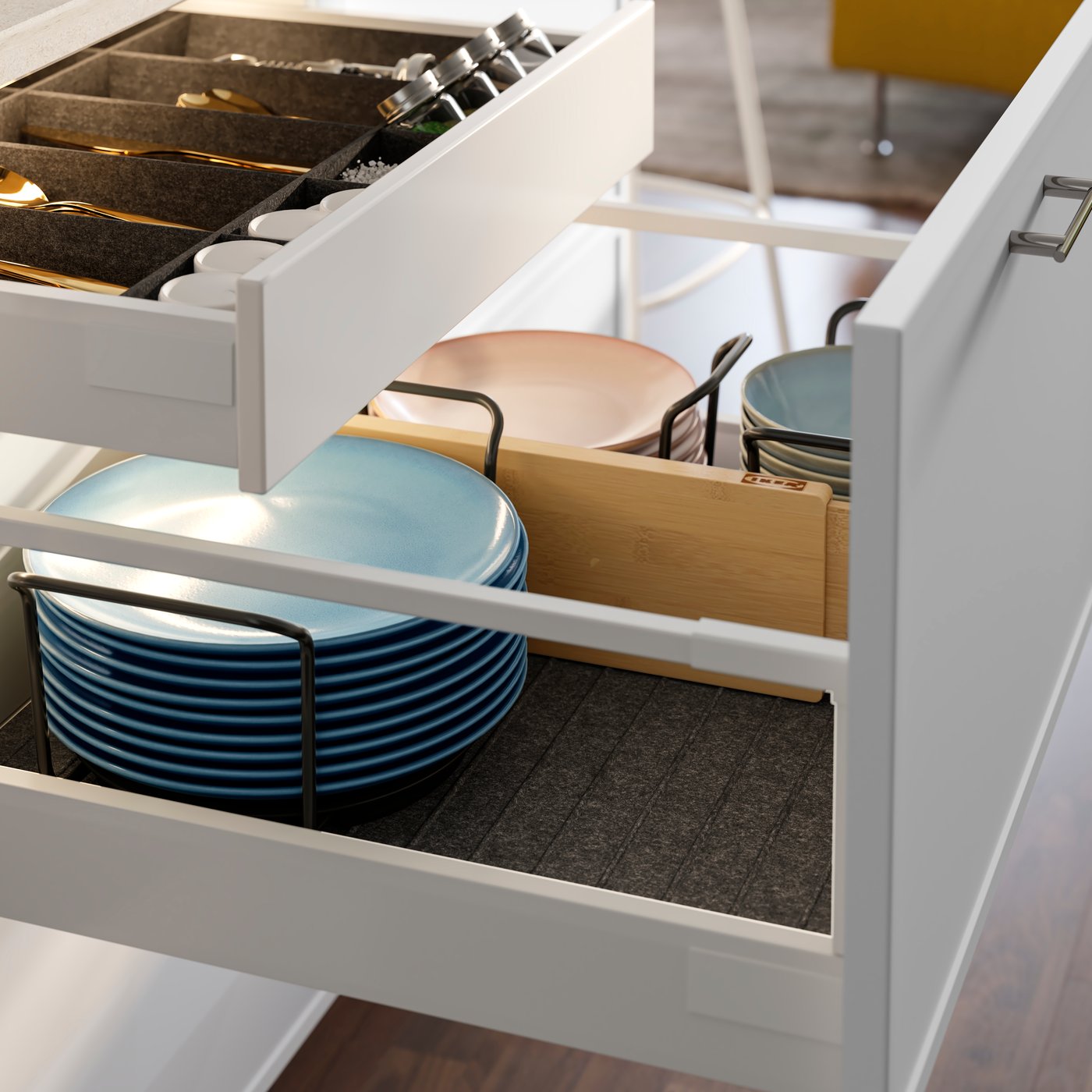 A close-up of a white VARIERA drawer divider in a kitchen drawer, storing  plates and bowls tools in an neatly and organised.