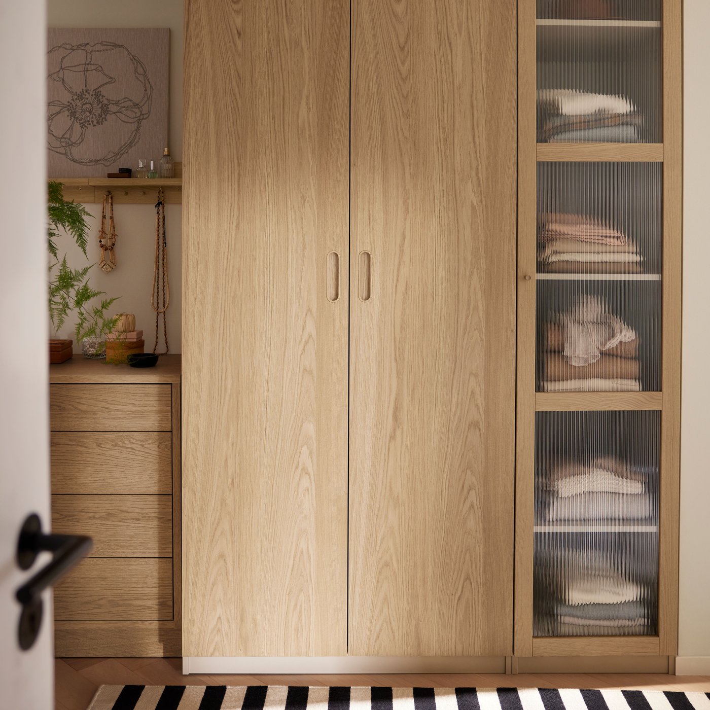 TONSTAD komoda od hrastovog furnira s 4 fioke stoji pored PAX/TONSTAD garderobera s dvoja vrata od hrastovog furnira i jednim staklenim vratima.