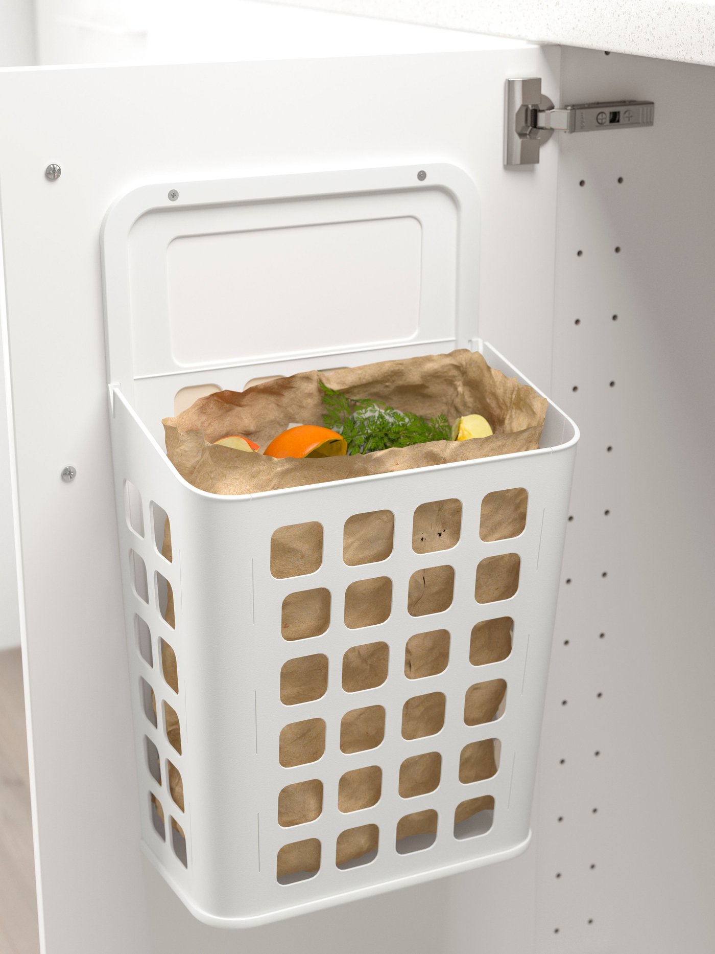 حاوية نفايات VARIERA بيضاء مبطنة بكيس ورقي بني ومعلقة داخل باب خزانة قاعدة مفتوح. 