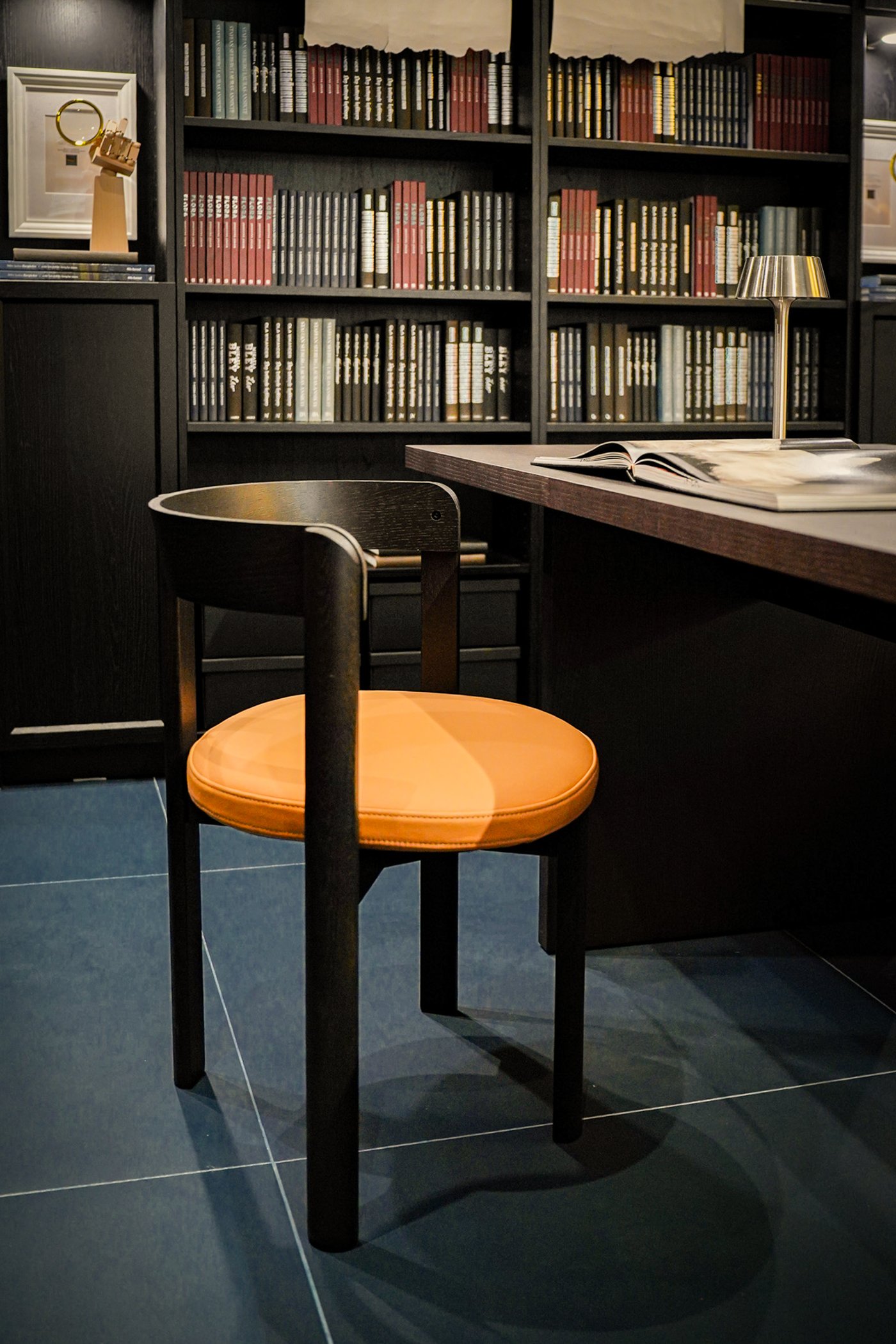 Curious Library room setting at IKEA Tampines, featuring a dark brown/leather STOCKHOLM 2025 chair.