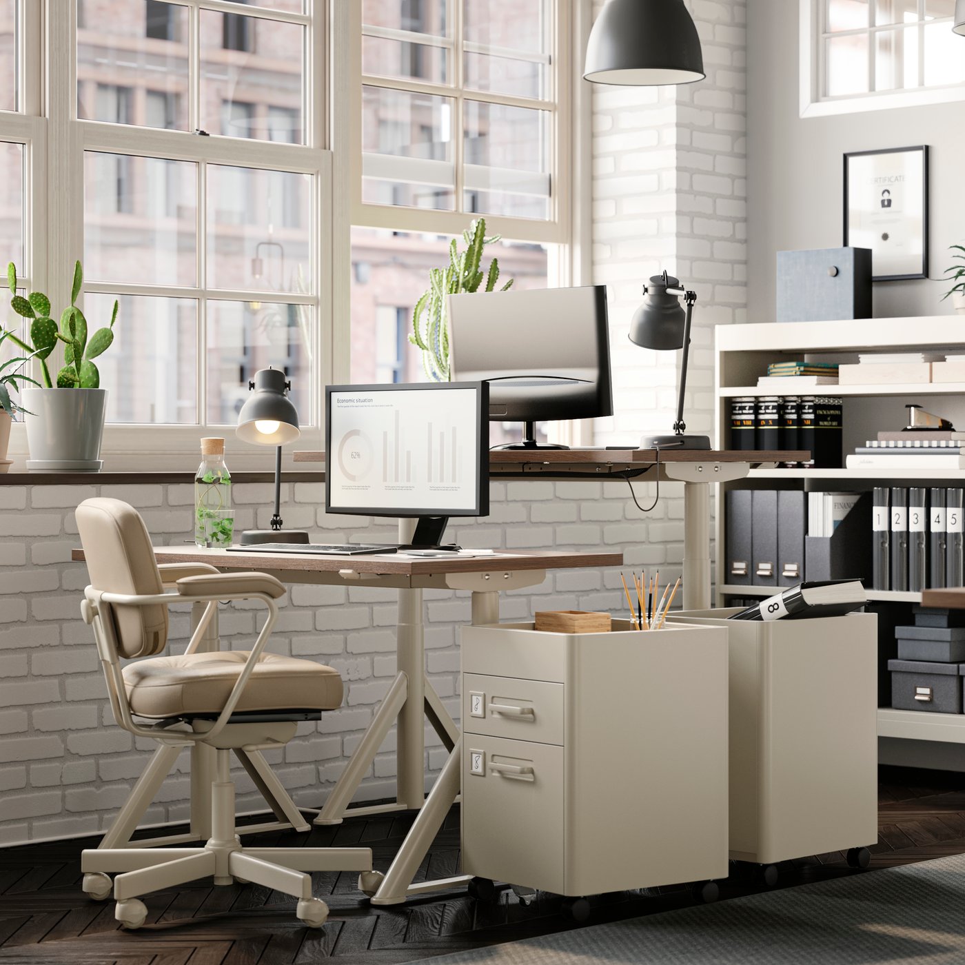 A light office with facing workspaces. An ALEFJÄLL office chair stands next to IDÅSEN sit-stand desks and drawer units.