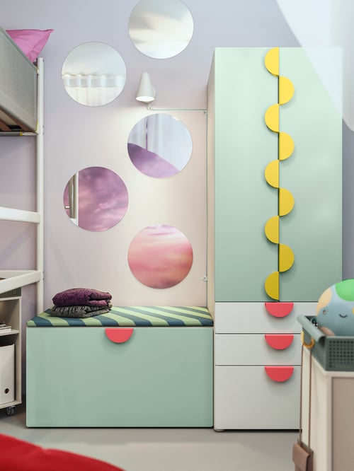 Kinderzimmer mit einer SMÅSTAD Aufbewahrungskombi, mehreren BLÅSER Spiegeln und einer FUBBLA LED-Wandleuchte.