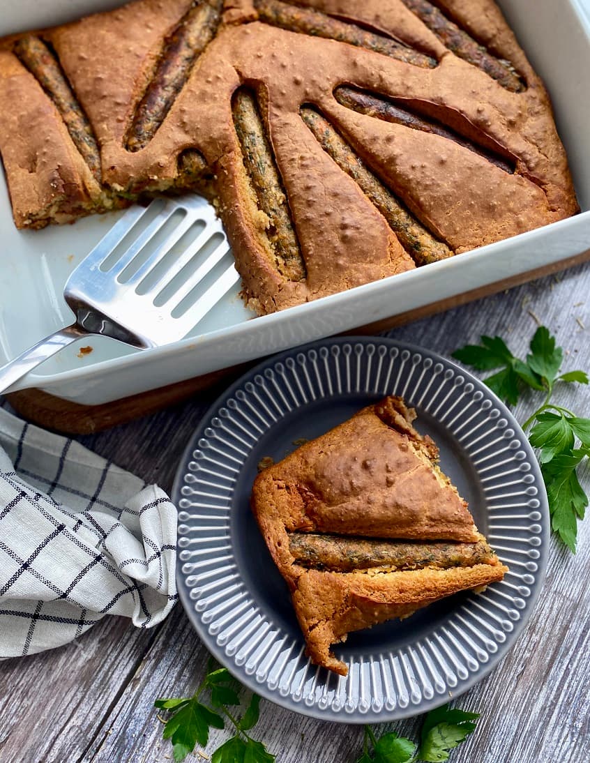 Une part de gâteau Toad-in-the-Hole dans une assiette, accompagnée d'une fourchette, prête à être dégustée.