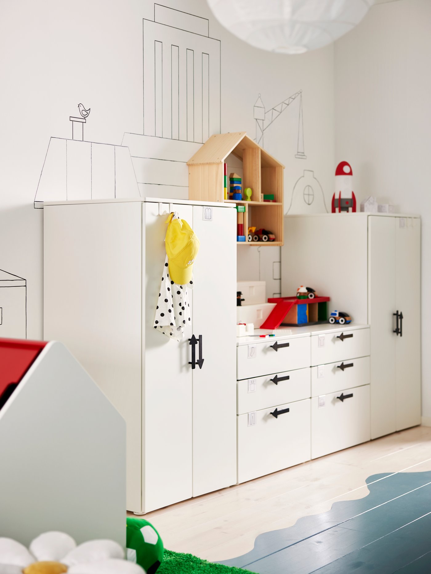 SMÅSTAD/PLATSA storage units along a wall with painted decorations and FLISAT doll’s house on it. Blue sea painted on floor.