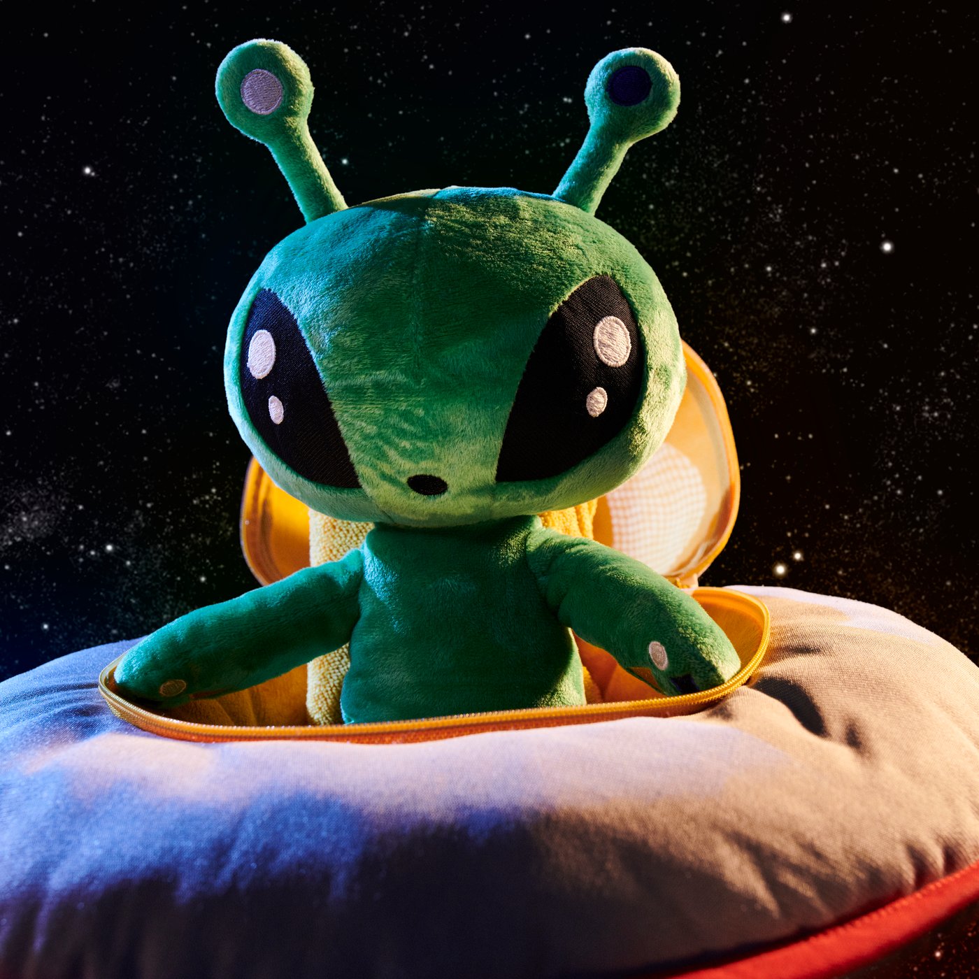 AFTONSPARV alien plush toy sitting in a UFO toy.