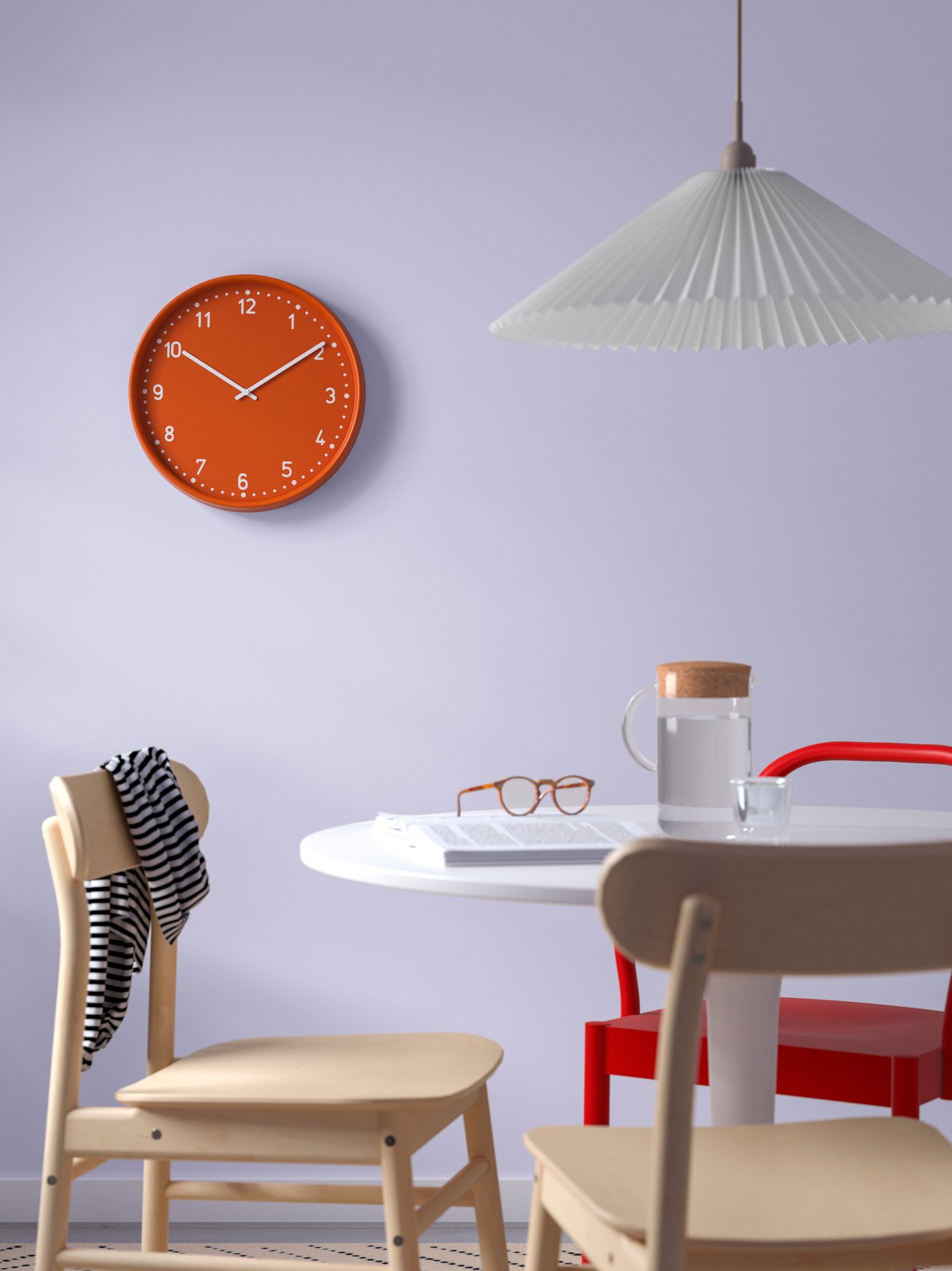 Un orologio da parete BONDIS arancione sulla parte color viola di una cucina.