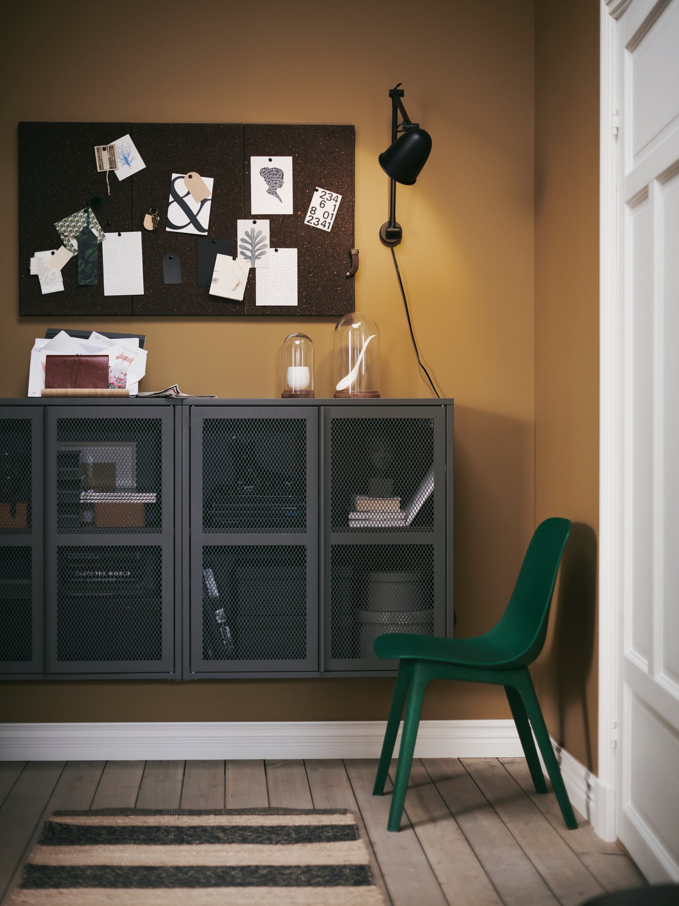 A hallway with wall-mounted solutions like IVAR cabinets with doors, SVENSÅS memo boards and a SKURUP work/wall lamp.