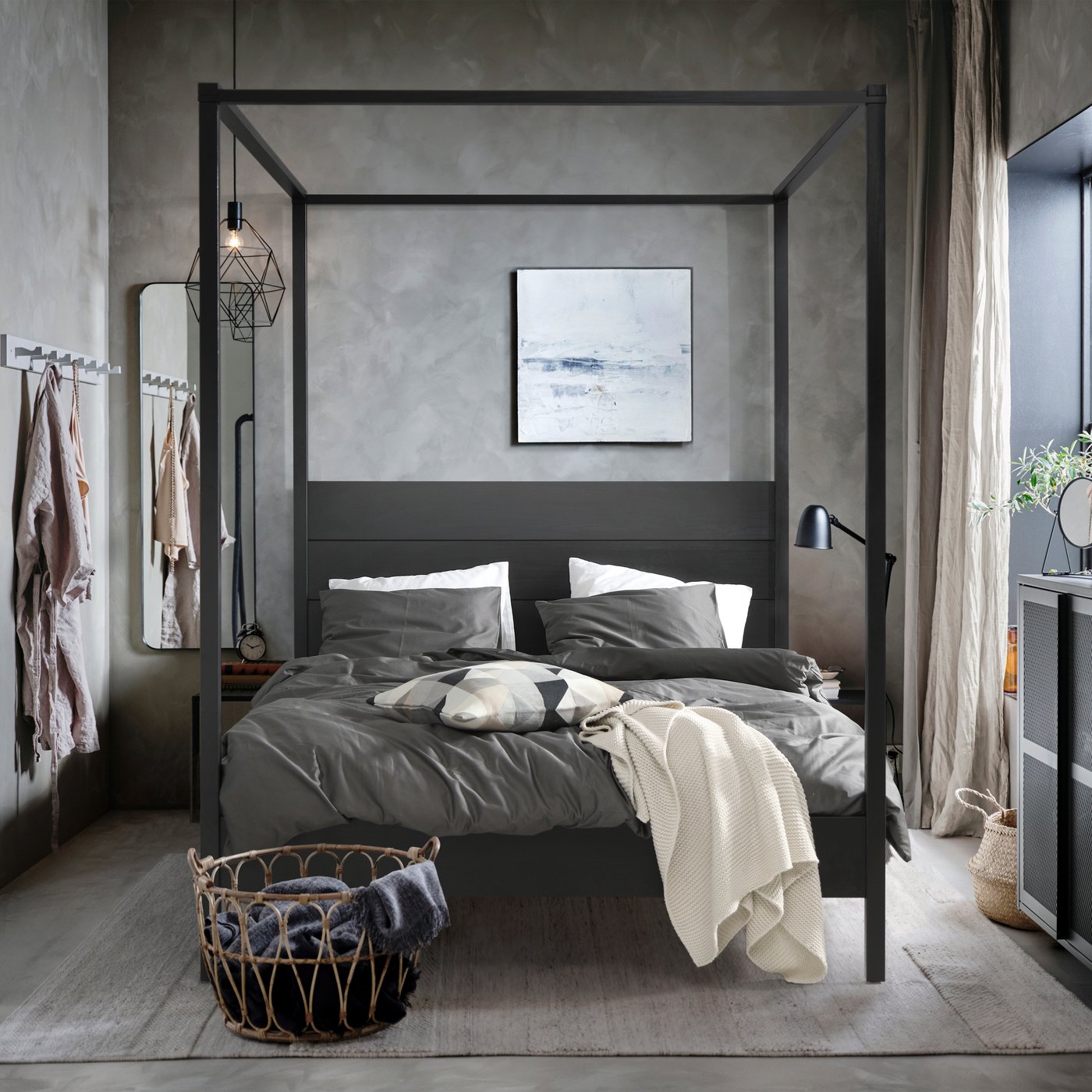 Ein schwarzes YTTERVÅG Himmelbett ist in einem Schlafzimmer zu sehen.