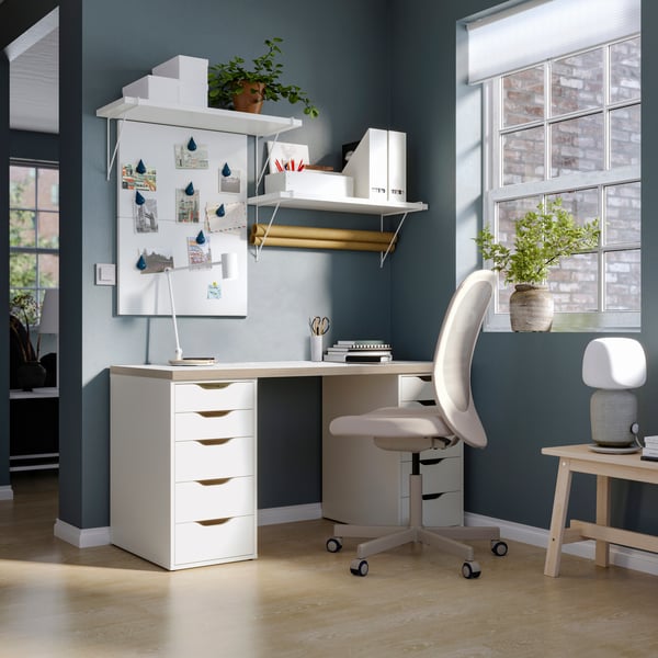 Una oficina equipada con escritorio, dos cajoneras, una silla ergonómica de escritorio. Sobre el escritorio hay un par de repisas almacenando cajas y otros artículos de oficina.