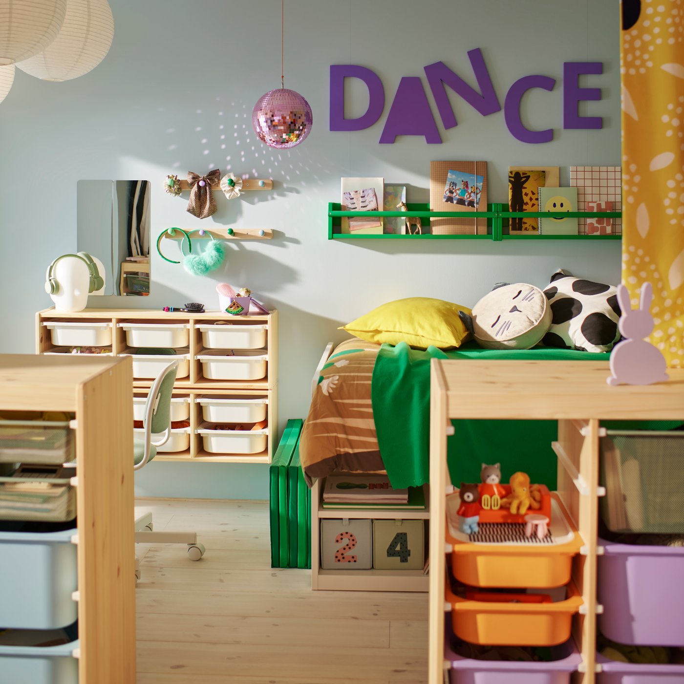 Jedna strana zajedničke dečje sobe koja je podeljena TROFAST paravanom na kojoj se vide SLÄKT krevet i FLISAT zidni element za odlaganje.