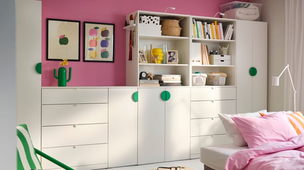 A white LASTARE wardrobe combination in a living room with pink walls.
