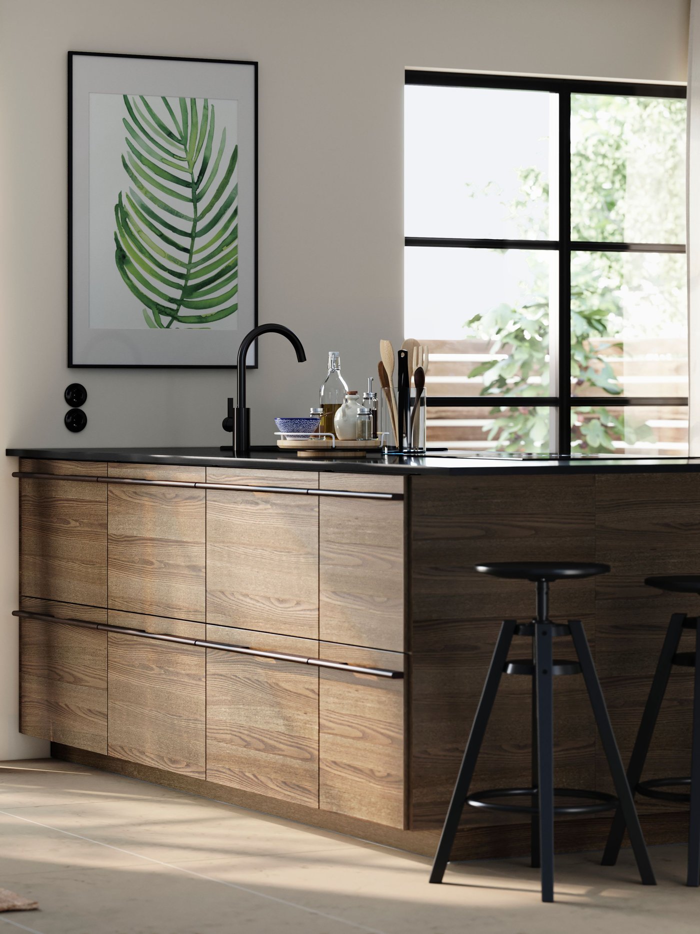 Eine Kücheninsel mit STENSTA Fronten in dunkelbraunem Eschenfurnier, ergänzt durch Barhocker und einen großen Pflanzendruck an der Wand.