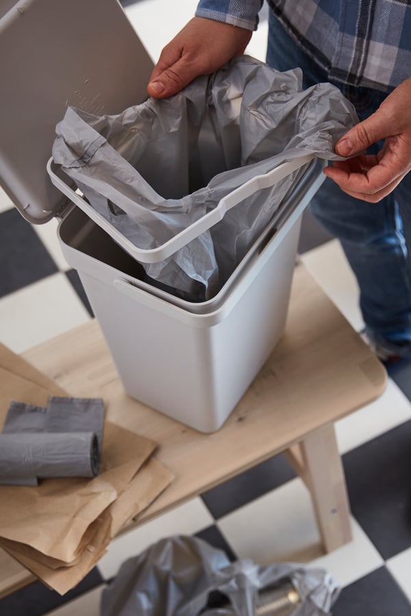 A light grey HÅLLBAR bin with lid and a bin bag
