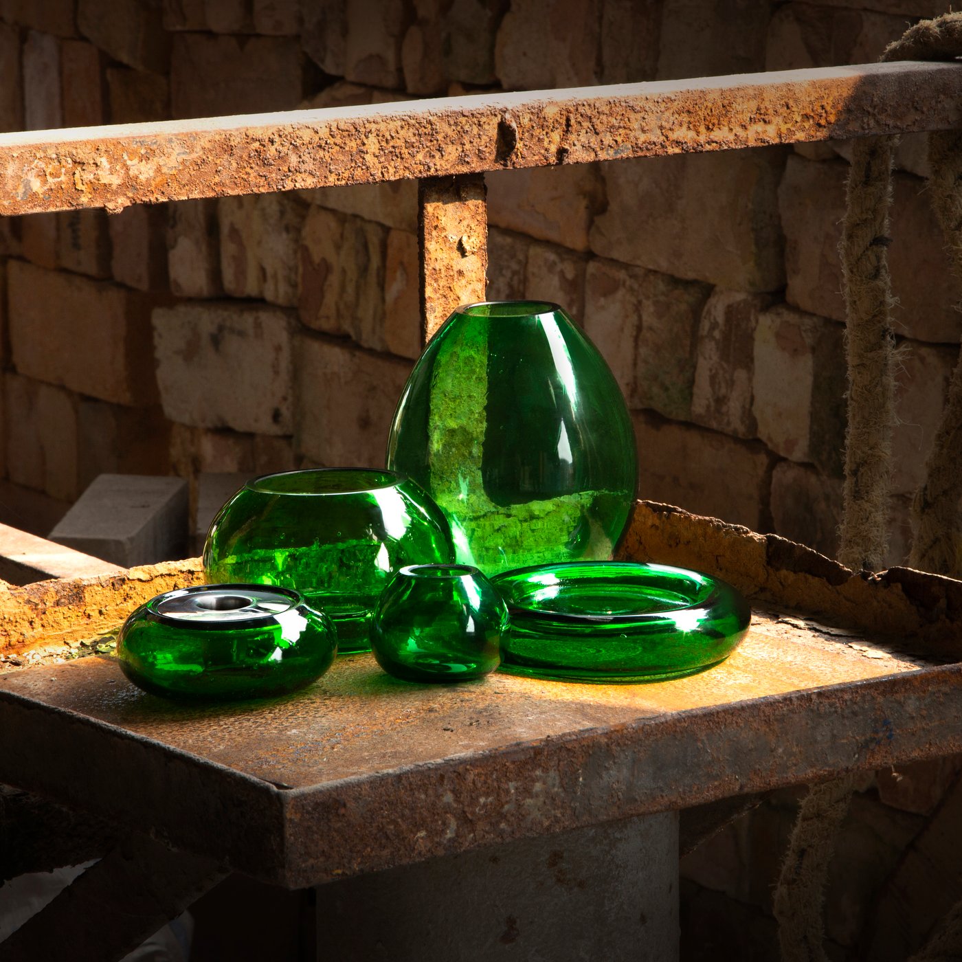 HÄNGBJÖRK Vasen und Kerzenständer sind in einer Glasbläserei in einem Regal zu sehen.