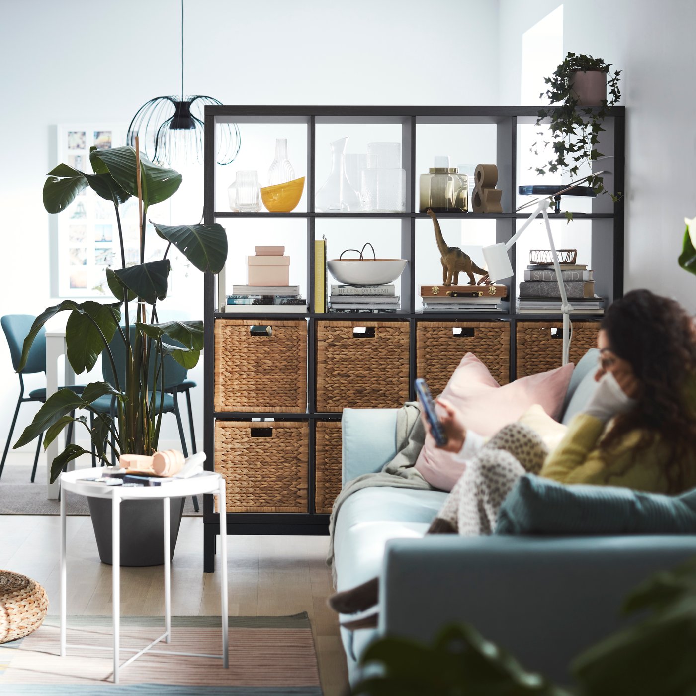 A black-brown/black KALLAX shelving unit with underframe in the living room