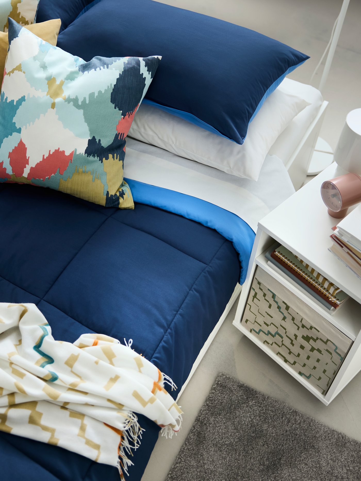 An off-white/multicolour OLIVSPINNMAL throw in the bedroom