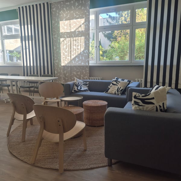 Przestrzeń wyposażona meblami IKEA, dwa krzesła brzozowe, sofa