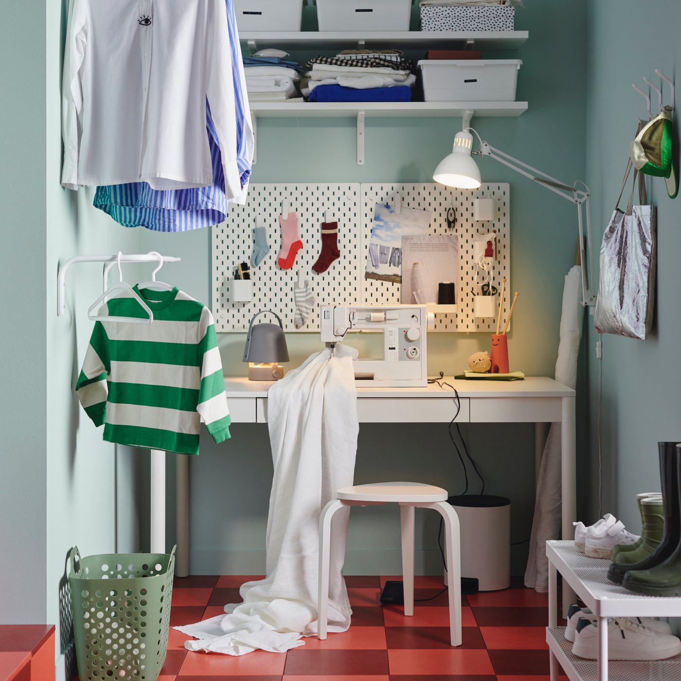 A grey, bell-shaped VAPPEBY Bluetooth speaker lamp helps light a mending station area in part of a modern laundry room.