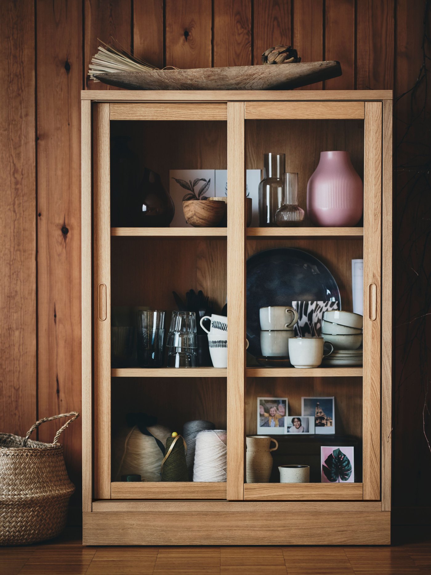 An oak veneer TONSTAD cabinet with sliding glass doors