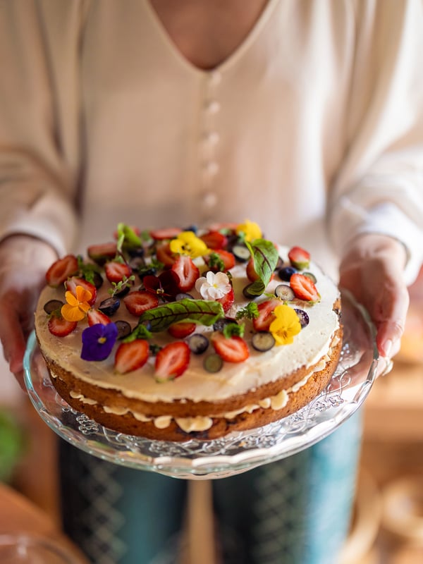 A person holding a midsummer cake.
