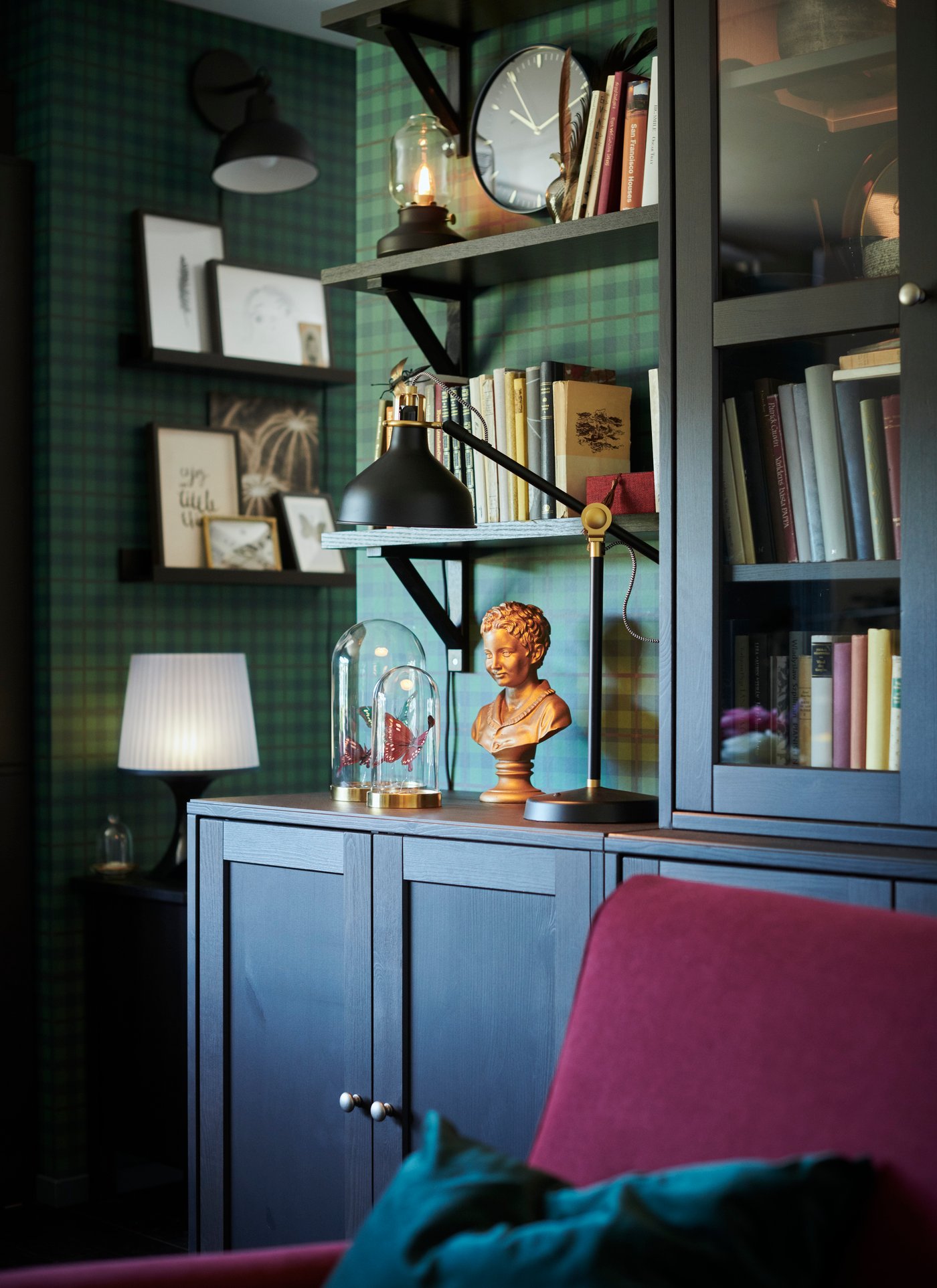 Front view of a cabinet on the wall above a desk and a SYMFONISK speaker. The image has a blue tone because of the VATTENSTEN LED lighting strip.