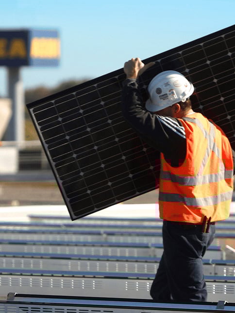 太陽光パネルをもって作業している様子