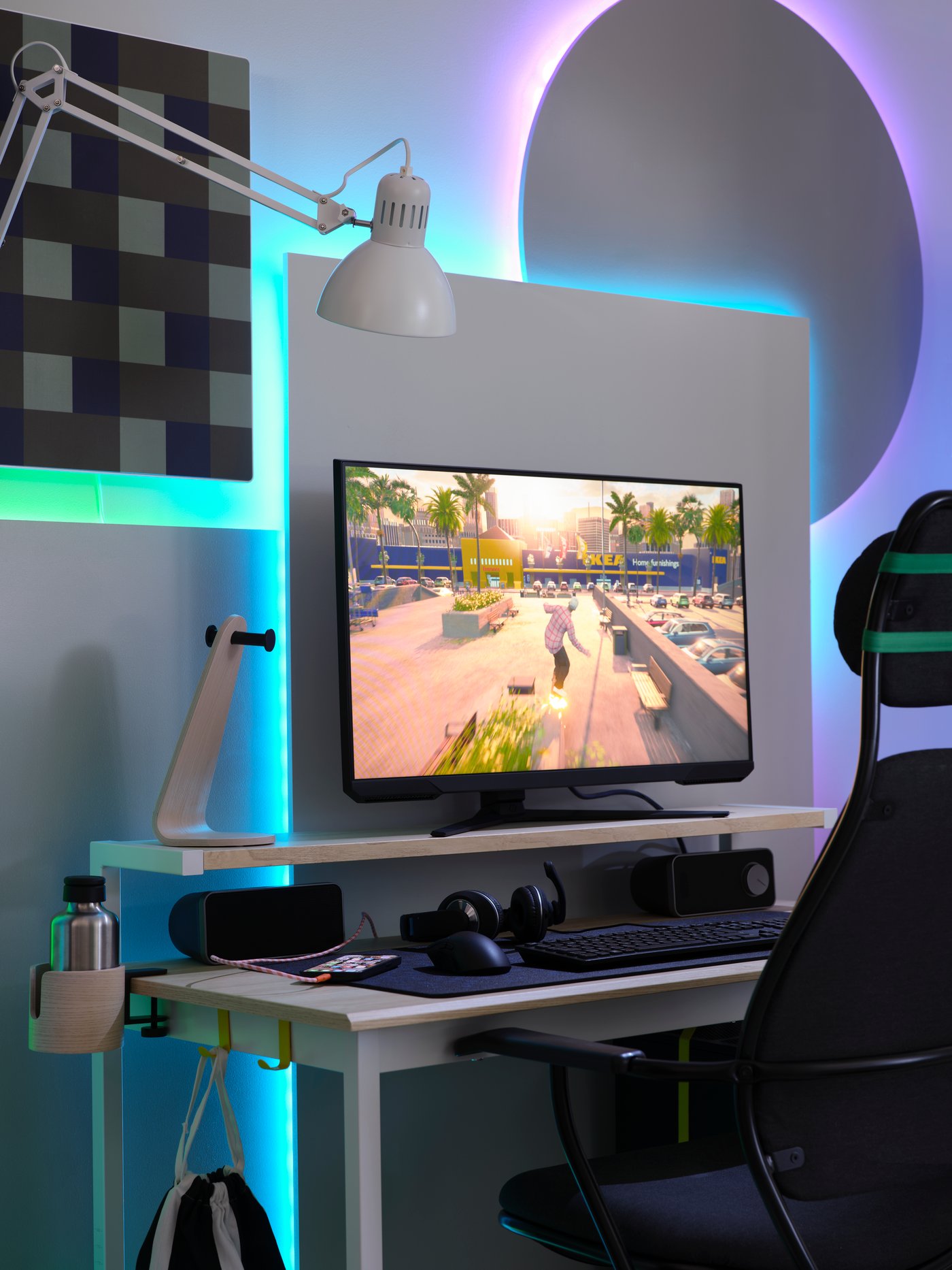 An ash effect/white PC gaming setup has a big shapes behind it that are backlit by unseen VATTENSTEN LED lighting strips.