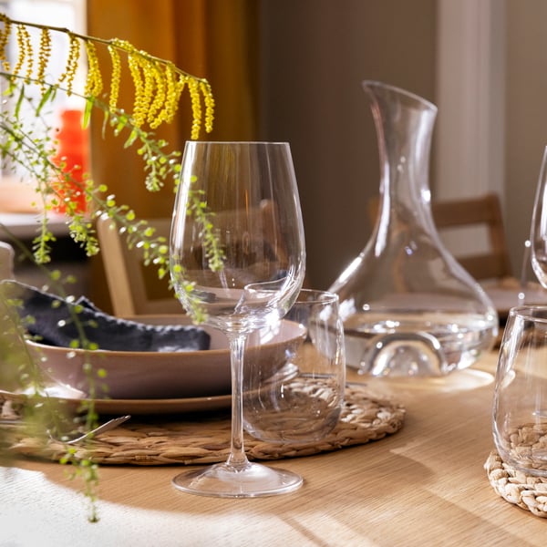 A table set for a festive occasion with some STORSINT glasses and a STORSINT carafe and FÄRGKLAR tableware.