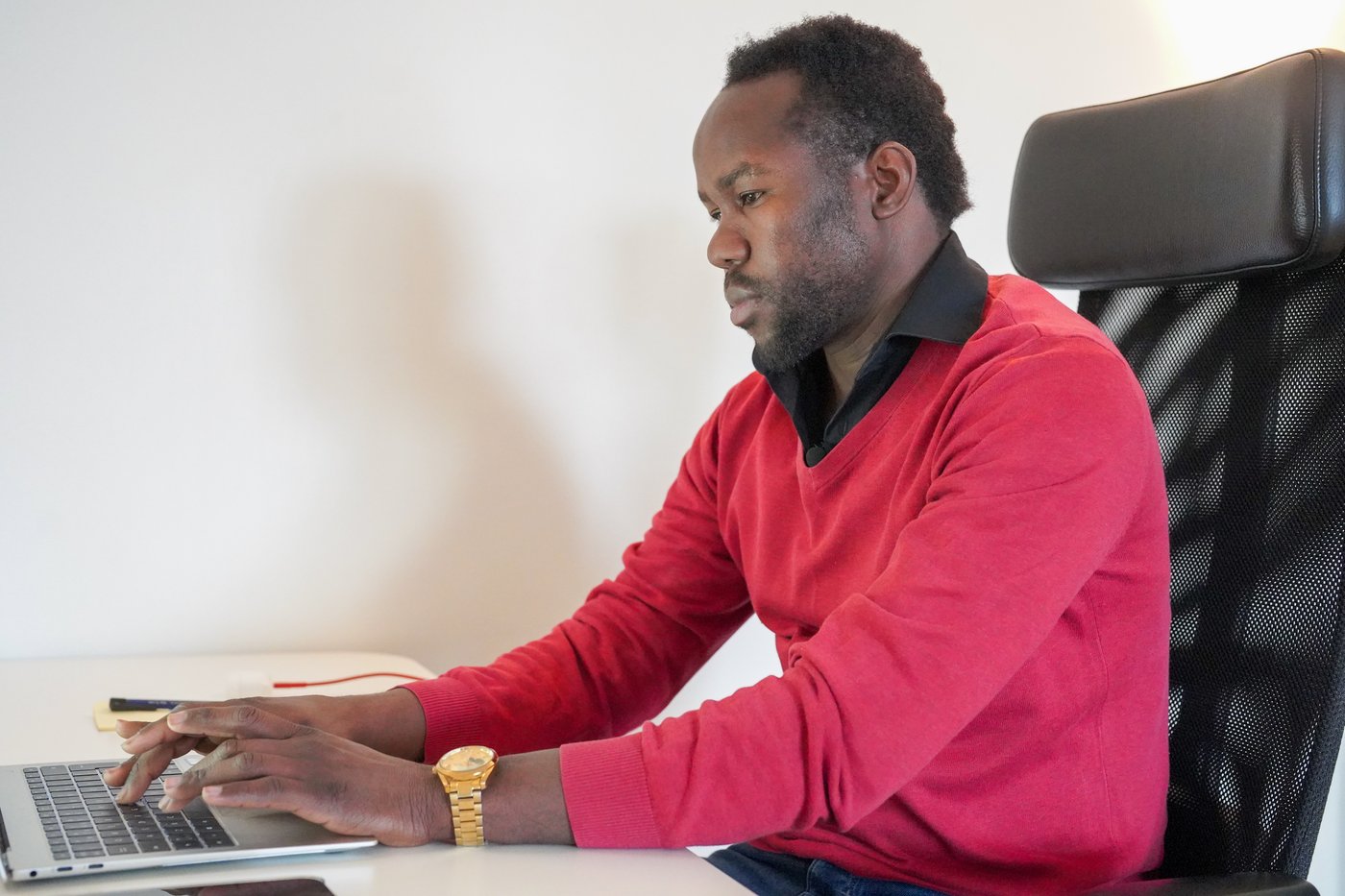 A man sitting at his office working on his laptop. 