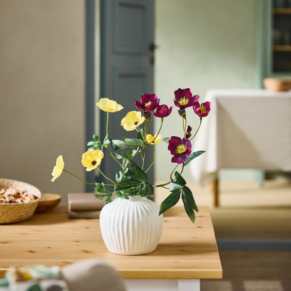 An in/outdoor Ranunculus/yellow SMYCKA artificial flower in the dining room