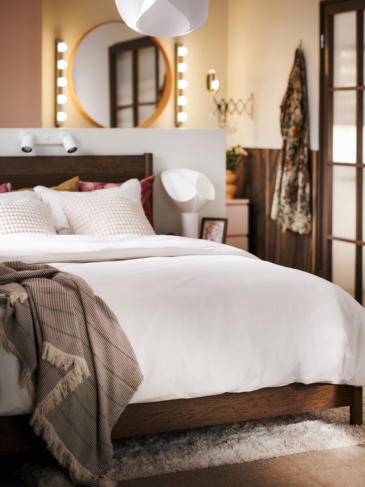 Un letto TONSTAD marrone con contenitore, rivestito con biancheria da letto HAMPFLOCKEL e con una coperta LAPPKATTFOT sopra.