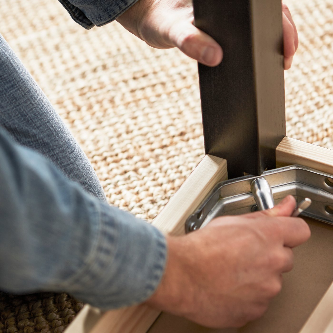 Hands assembling a piece of furniture