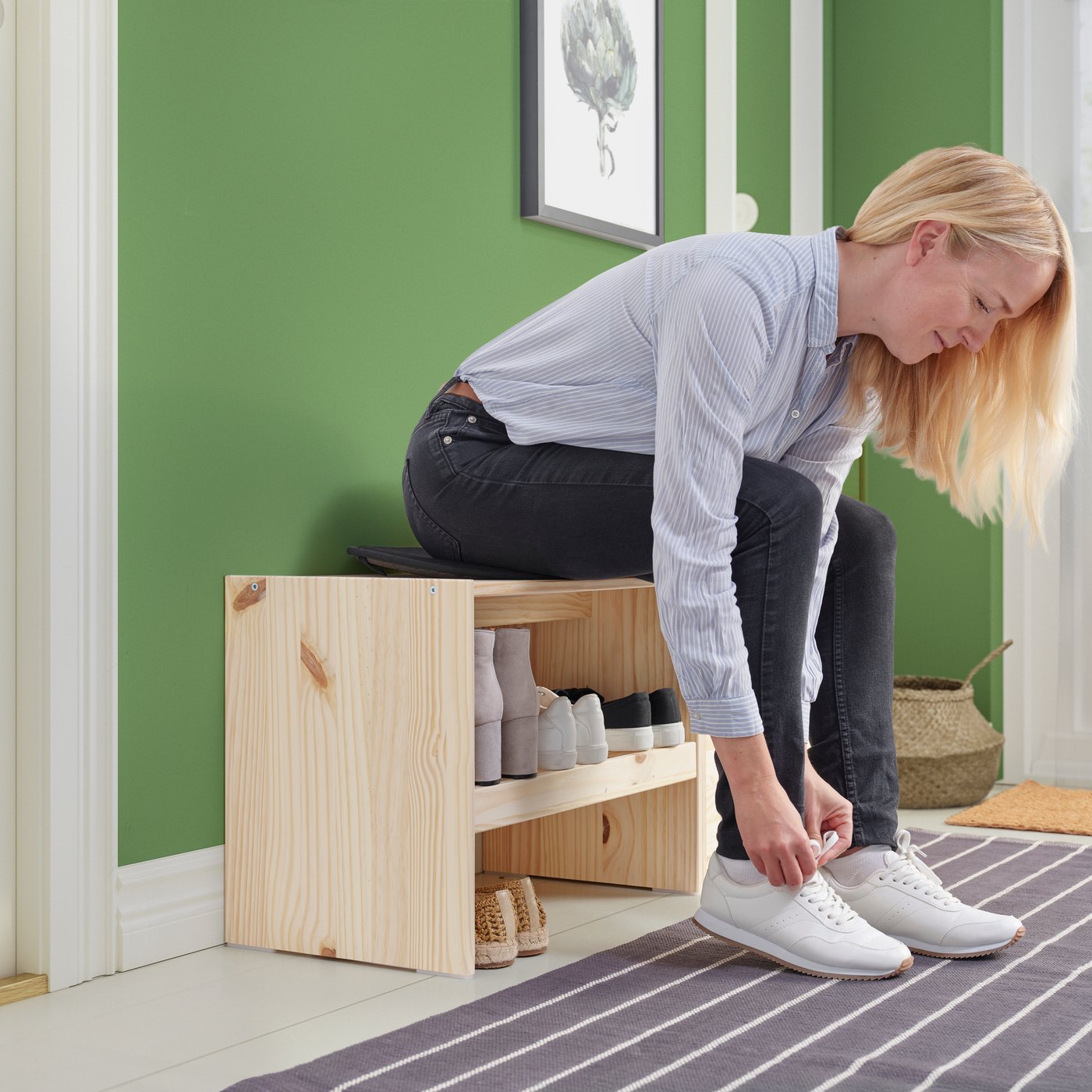 The left wall of a family hallway with RAGGBERG benches and coat racks in pine, with details painted in bright colours.