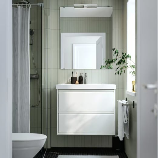 Una composizione bagno ÄNGSJÖN bianco lucido visto frontalmente con specchio rettangolare e accessori per il bagno.