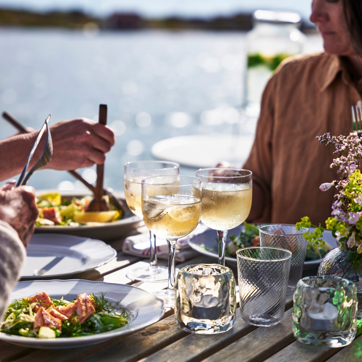 Family sitting waterfront sharing a meal
