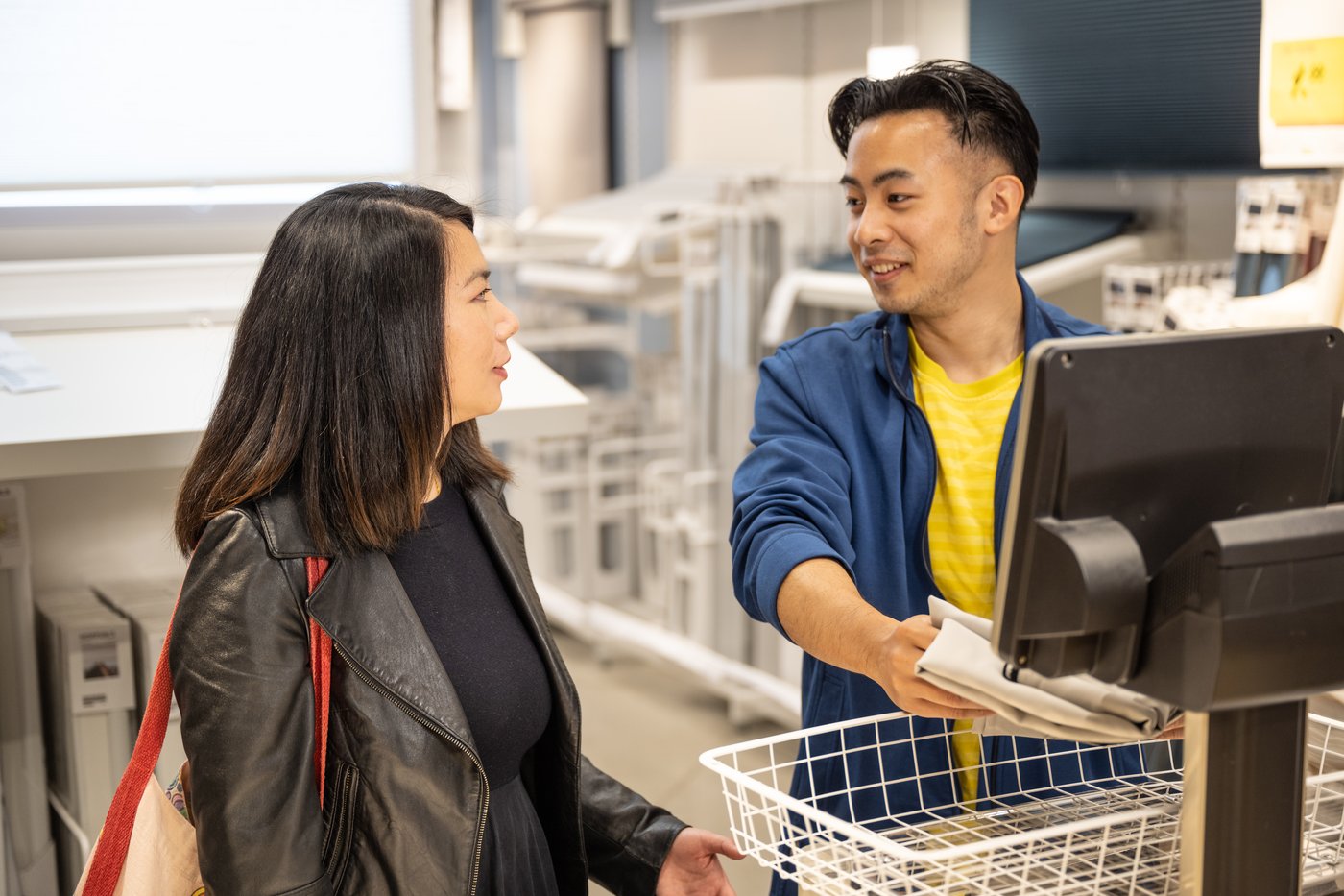 IKEA coworker assisting in-store customer at information kiosk as part of customer service