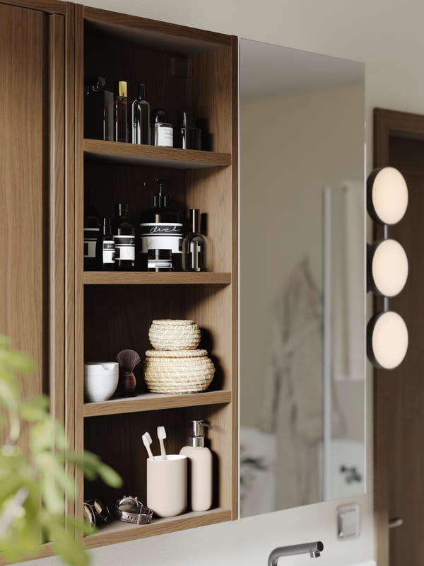 Dark wood bathroom cabinet with open shelving filled with bathroom products.