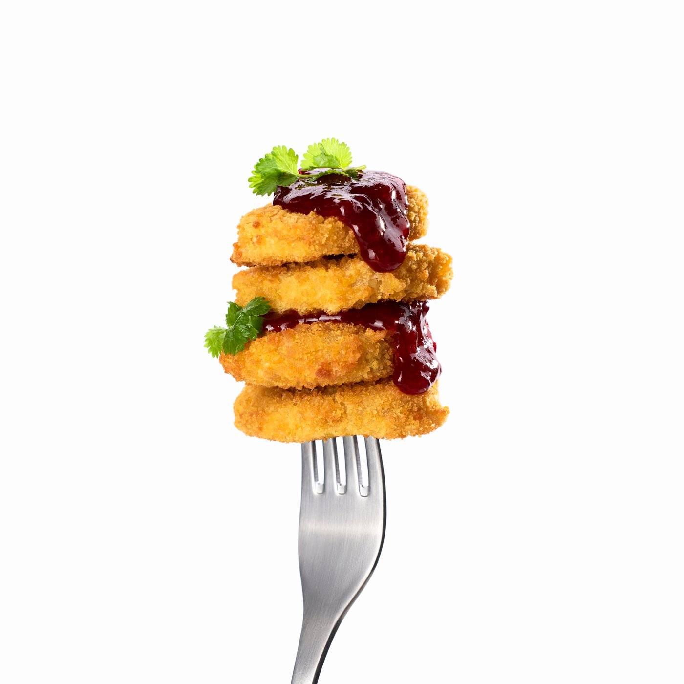 4 SLAGVERK plant-based pieces, dripping in sauce, stacked like a tower on the end of a fork.