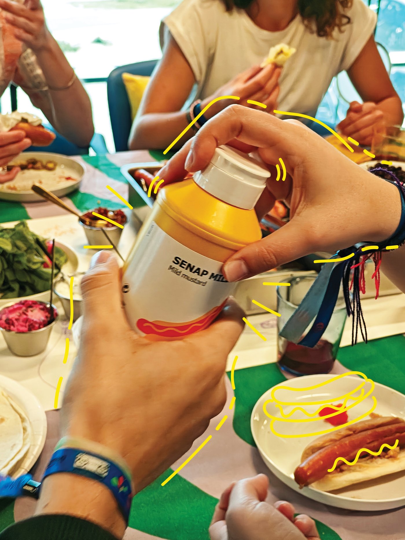 Person handing another person a bottle of SENAP MILD mild mustard.