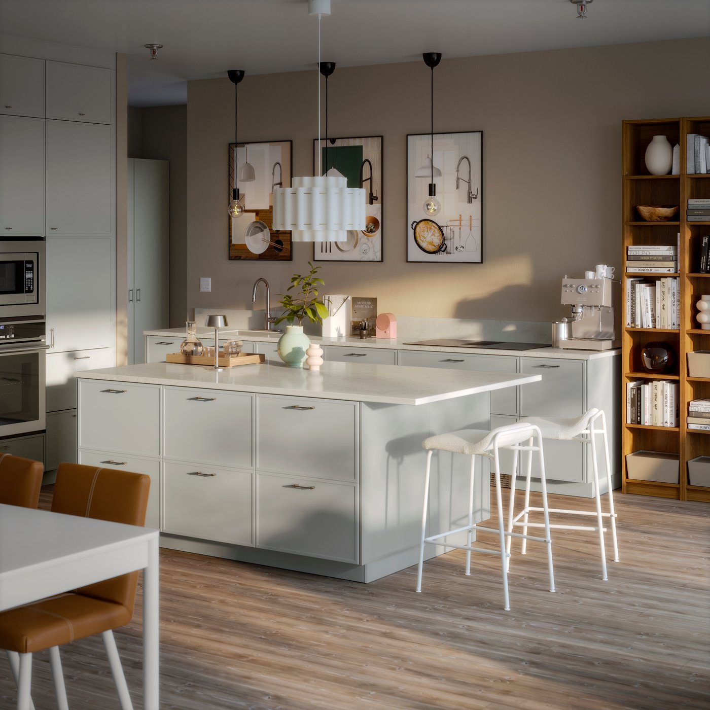 A display kitchen with a central island and white bar stools. Three posters are hung on the back wall.
