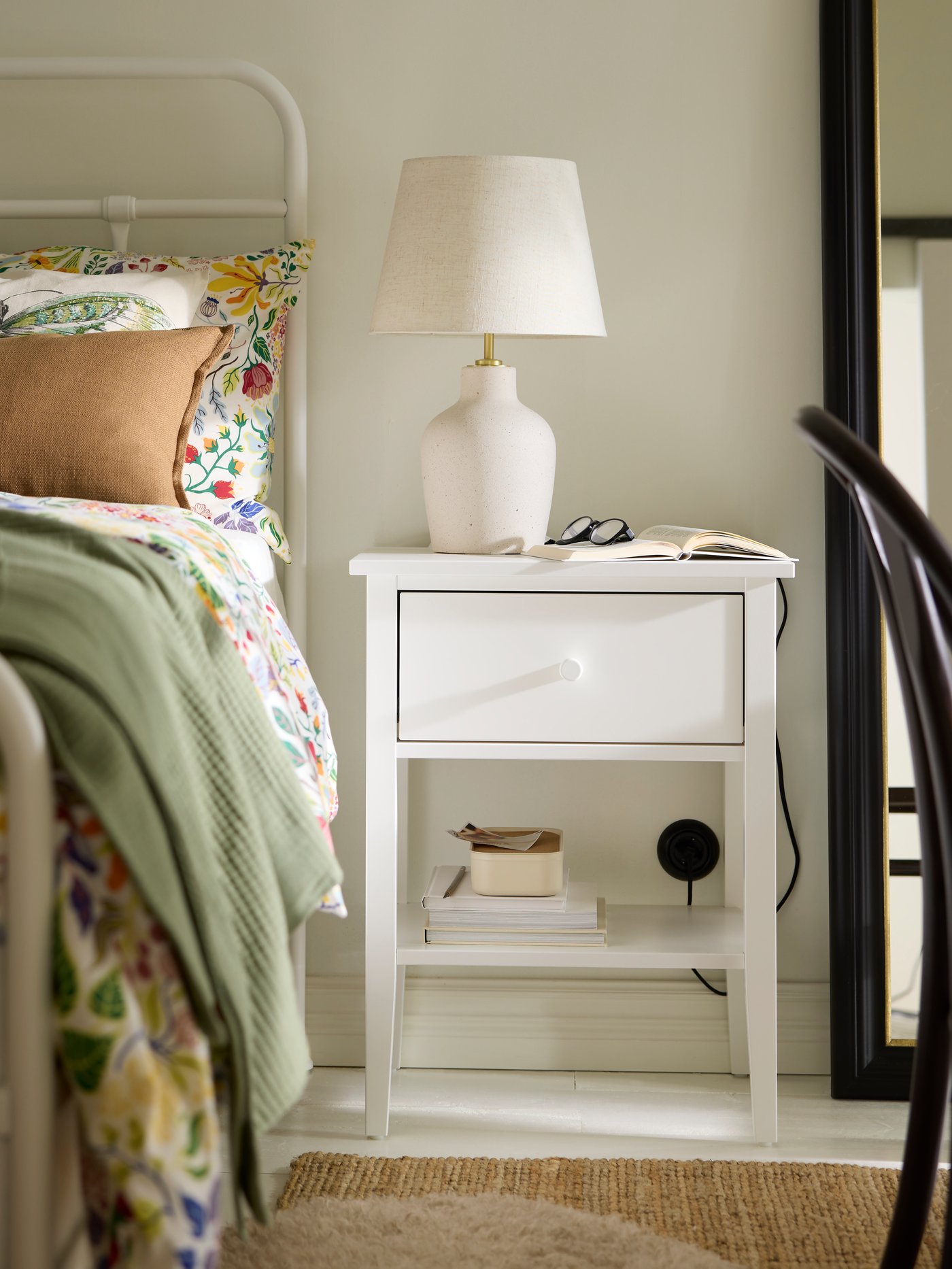 Ett vitt sängbord i traditionell stil.