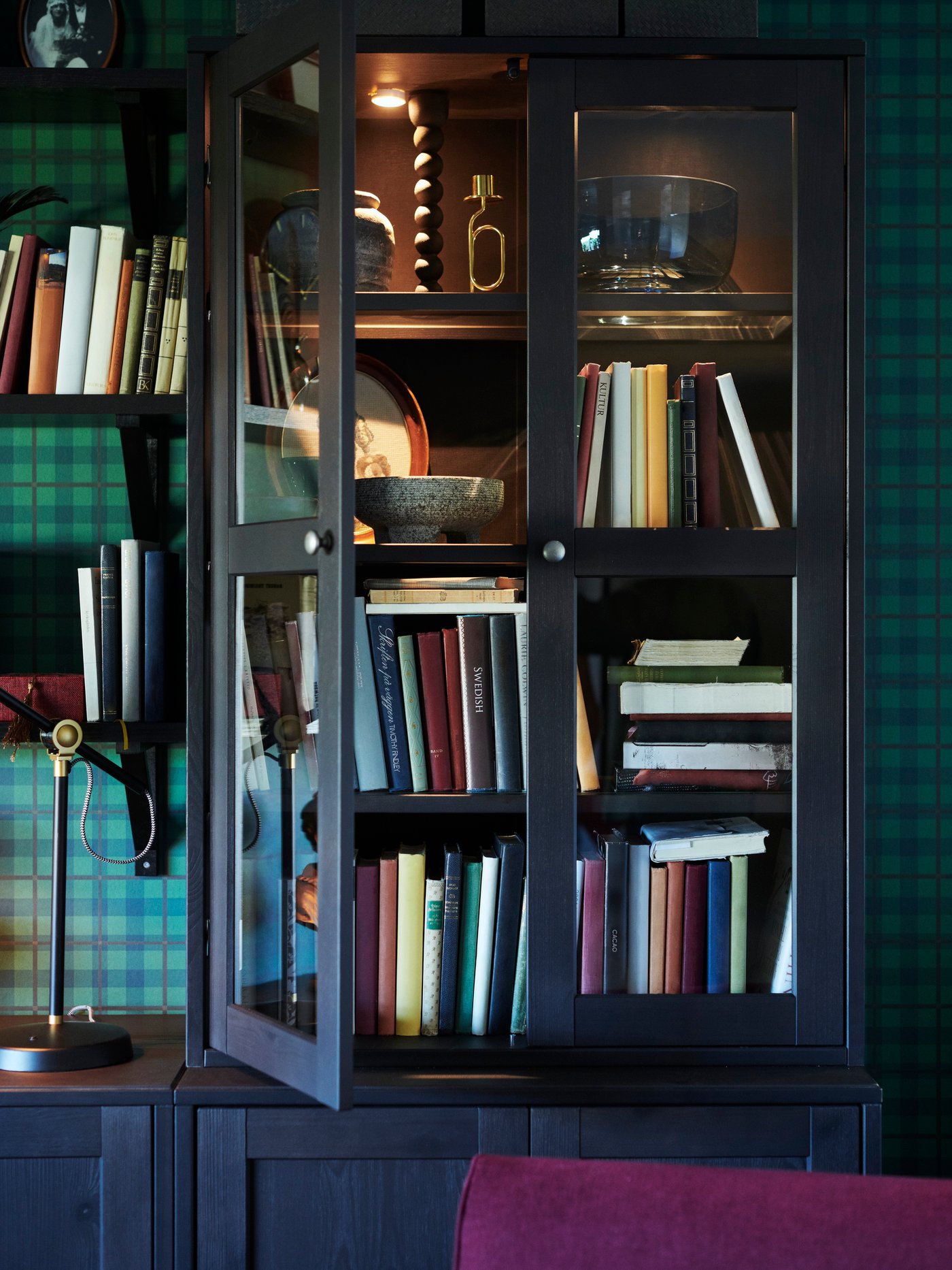 A grey HAVSTA storage combination is filled with decorative items, books, rattan baskets, vases and dried flowers.