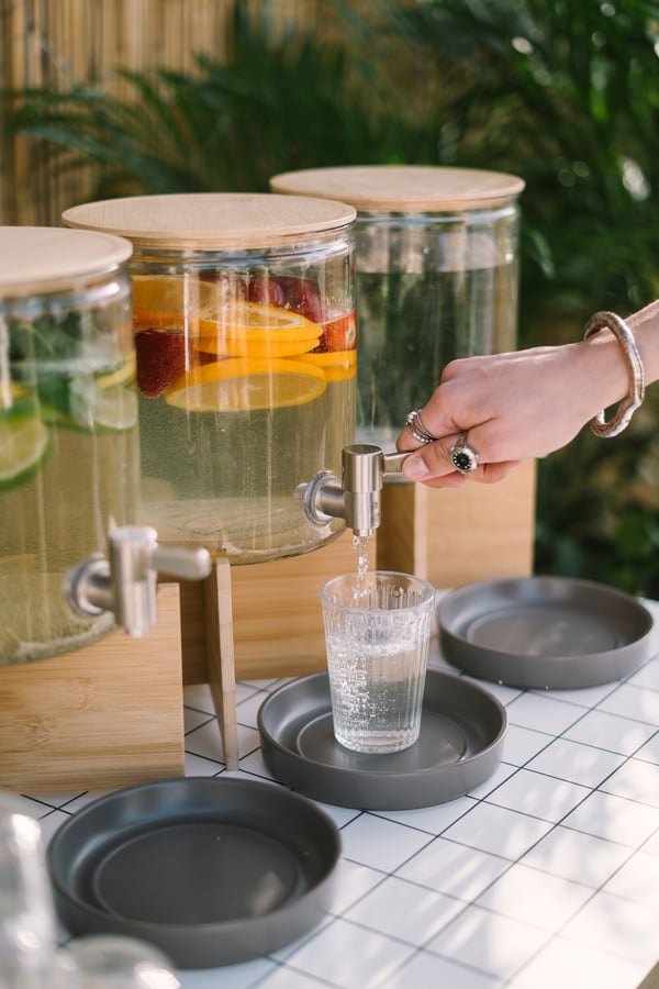 Una persona sta prendendo una bevanda aprendo un dispenser con rubinetto IKEA 365+. Accanto, altri due dispenser.
