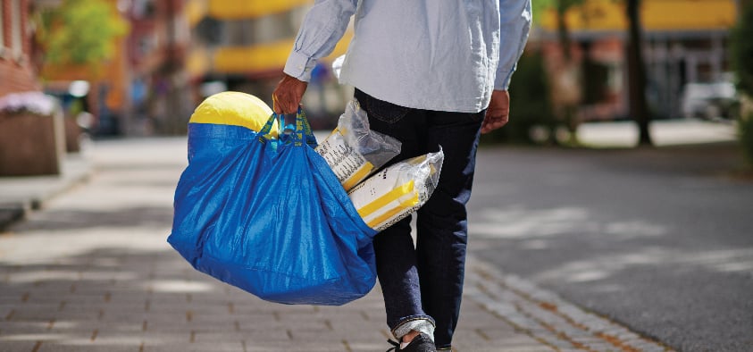 イケアのブルーバッグにイケアの商品が入っており、それを持って歩く人